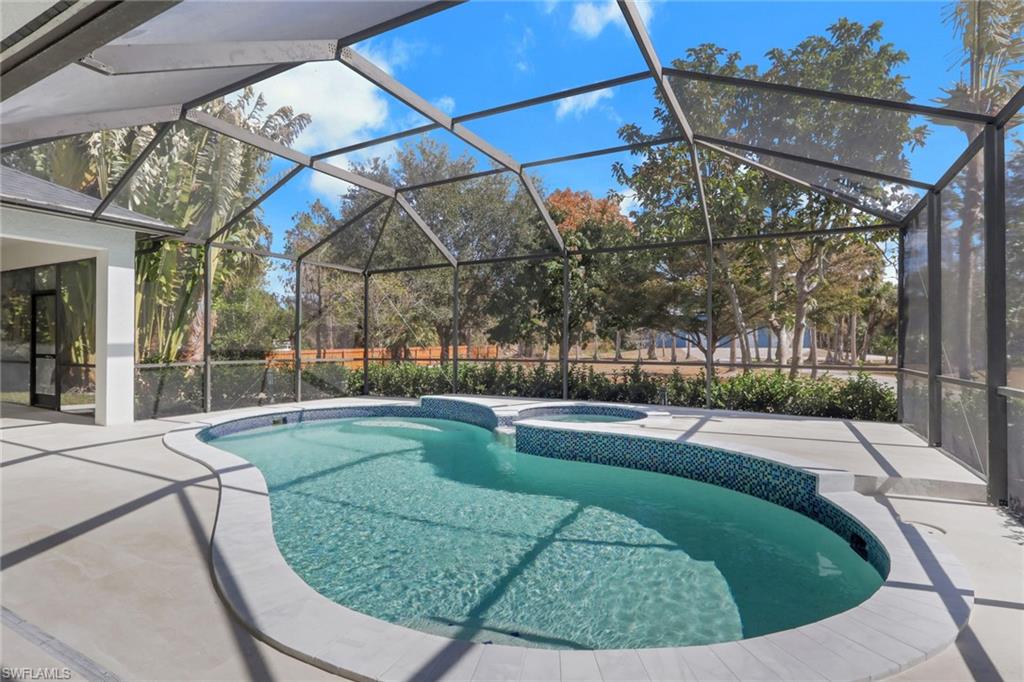 730 29th Street Southwest Naples, FL 34117 - Photo 39 of 50 Integrated pool / hot tub with a sunroom, glass enclosure, and a patio area