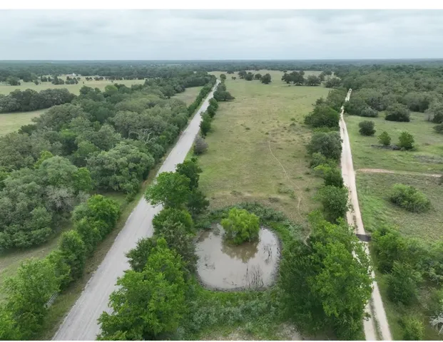 an aerial view of a houses with outdoor space and trees