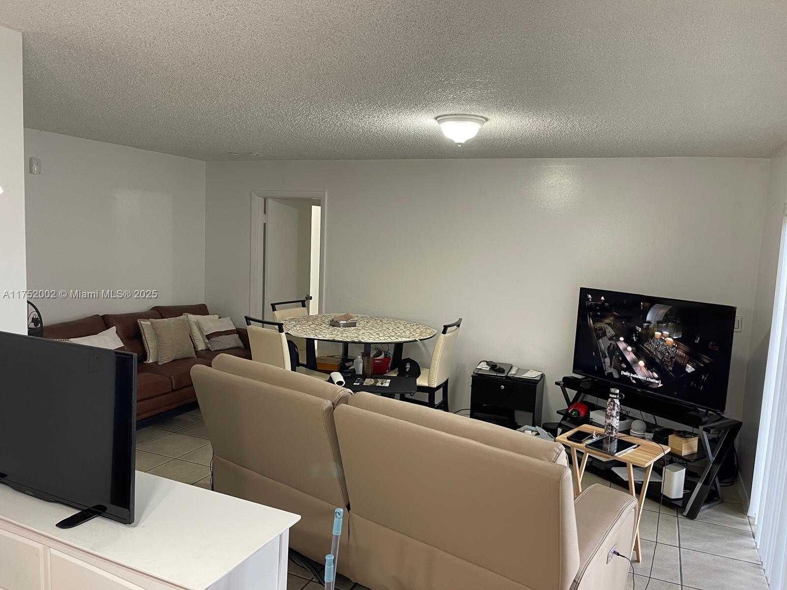 21133 Southwest 85th Avenue, Unit 112 Cutler Bay, FL 33189 - Photo 6 of 18 a living room with furniture and a flat screen tv