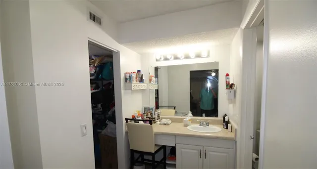 a bathroom with a sink vanity and mirror
