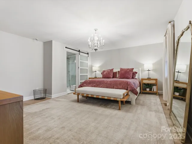 a spacious bedroom with a bed and a chandelier
