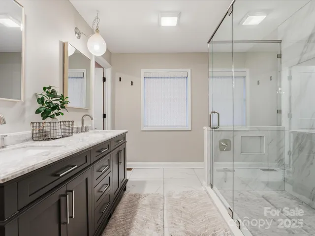 a spacious bathroom with a granite countertop sink mirror and shower