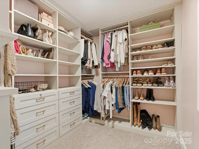 a view of walk in closet with clothes and shoes