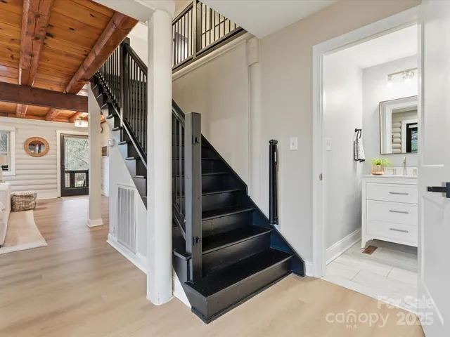 a view of hallway with stairs and wooden floor