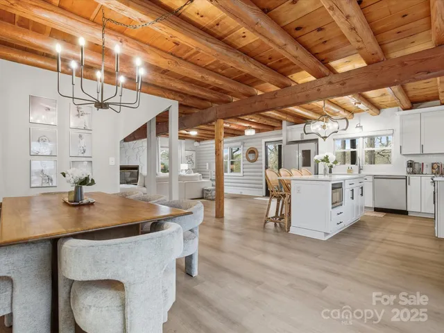 a living room with stainless steel appliances kitchen island granite countertop a sink cabinets and wooden floor