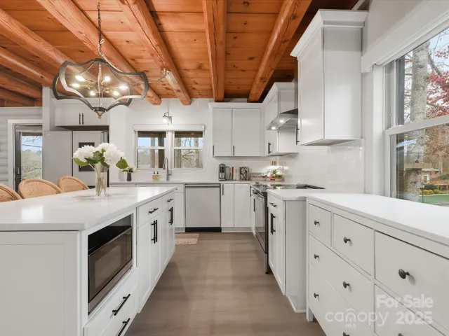 a kitchen with stainless steel appliances granite countertop a white cabinets a sink a stove a refrigerator and white cabinets