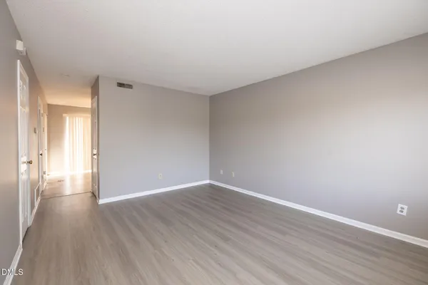 a view of an empty room with wooden floor