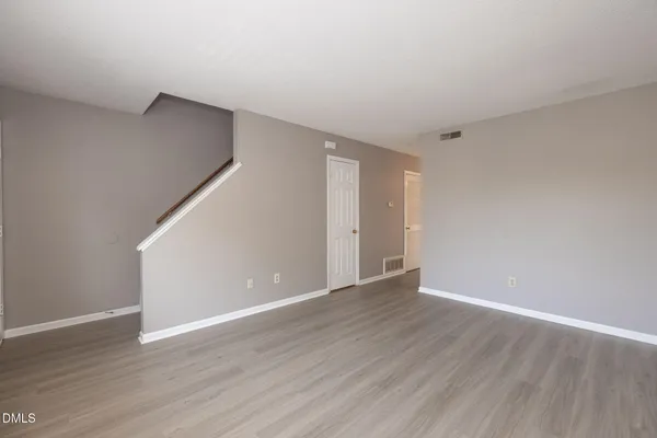 a view of an empty room with wooden floor