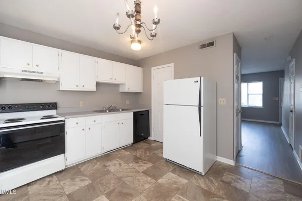 a kitchen with a refrigerator sink and cabinets
