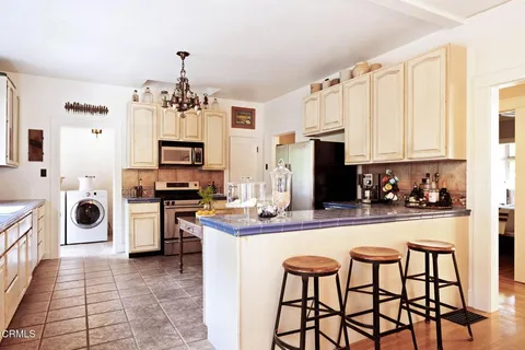a kitchen with stainless steel appliances granite countertop a stove a sink dishwasher and a refrigerator with wooden floor