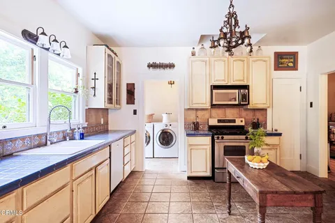 a kitchen with stainless steel appliances a stove sink and microwave