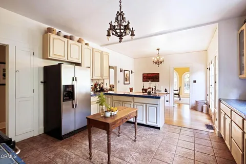 a kitchen with stainless steel appliances kitchen island granite countertop a refrigerator and a stove top oven