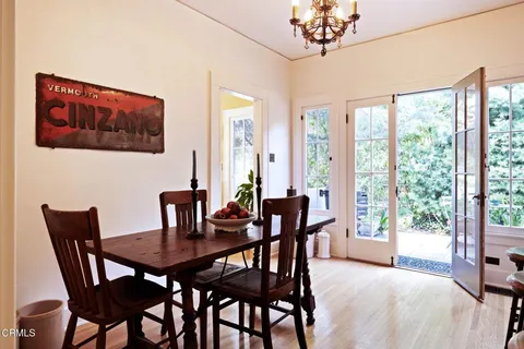 a view of a dining room with furniture a chandelier and wooden floor