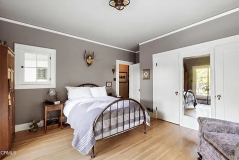 a bedroom with a bed and wooden floor