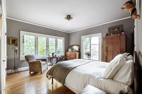 a bedroom with a bed and large windows