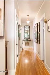 a view of a hallway with wooden floor and chandelier