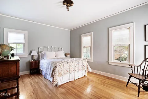 a bedroom with a bed a dresser and a window