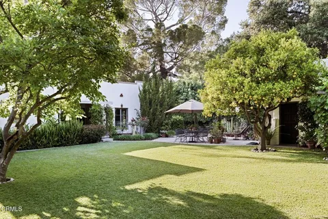 a front view of a house with swimming pool and garden
