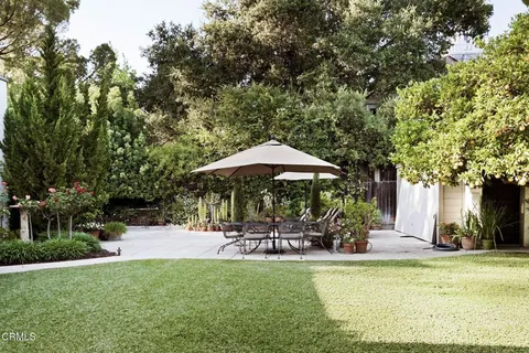 a view of a swimming pool with lawn chairs under an umbrella