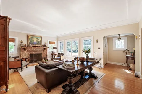 a living room with fireplace furniture flat screen tv and windows