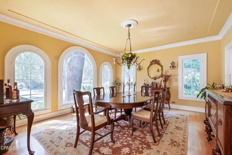 a view of a dining room and livingroom with furniture wooden floor a chandelier