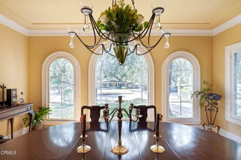 a living room with couches a table with wooden floor and a large window