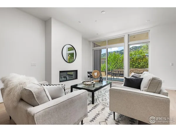 a living room with fireplace furniture and a large window