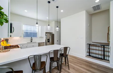 a kitchen with a table chairs refrigerator and microwave