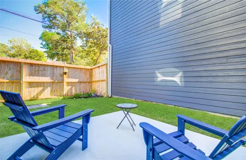 a view of a chairs and table in patio next to a yard