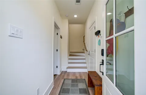 a view of a hallway with wooden floor and staircase