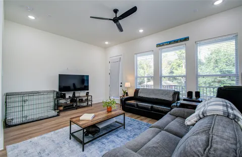 a living room with furniture a flat screen tv and a large window