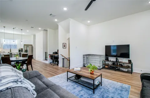 a living room with furniture and a flat screen tv with kitchen view