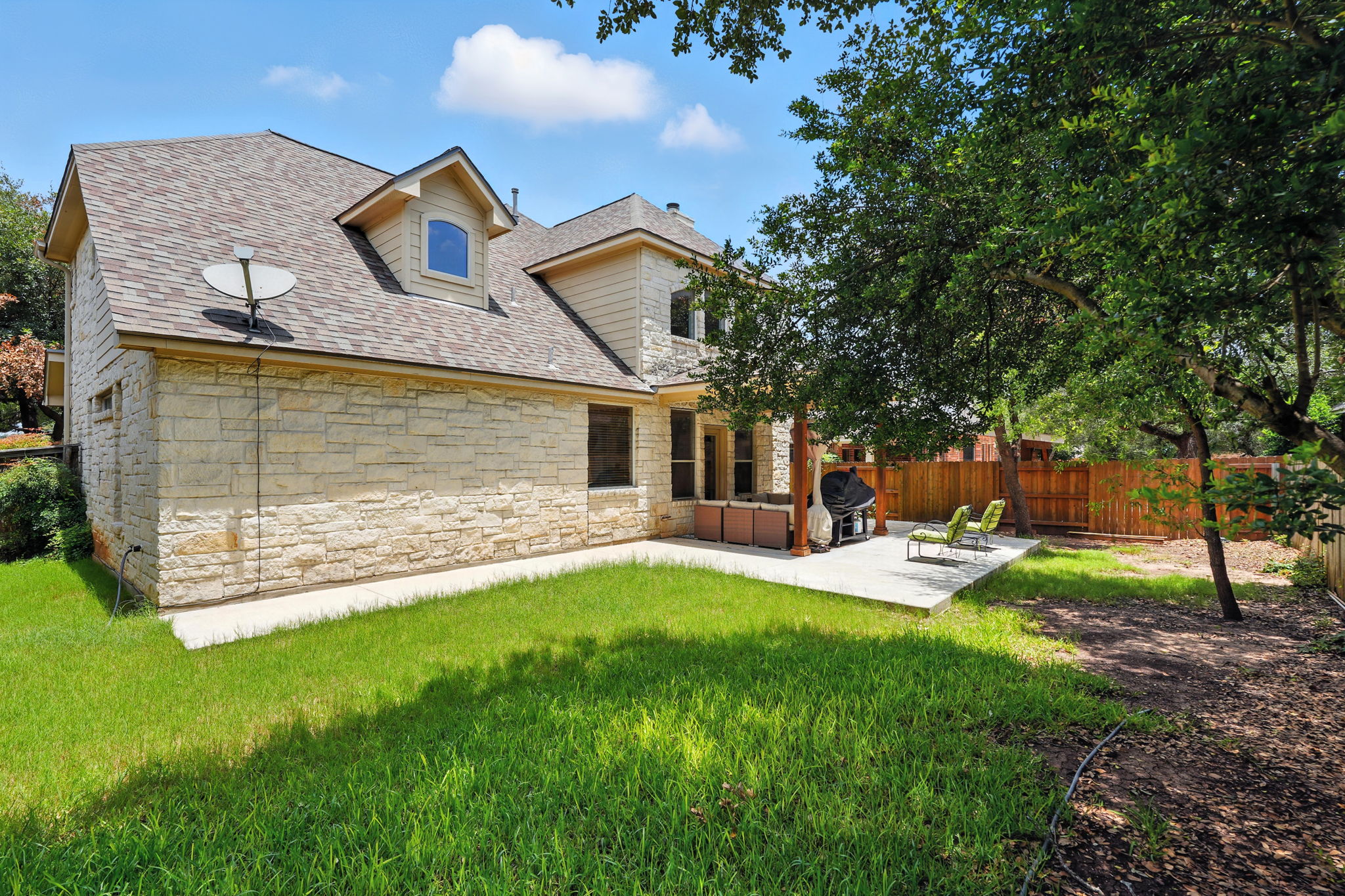 1802 Misty Ridge Leander, TX 78641 - Photo 35 of 39 Back of property with a shingled roof, a patio area, and stone siding