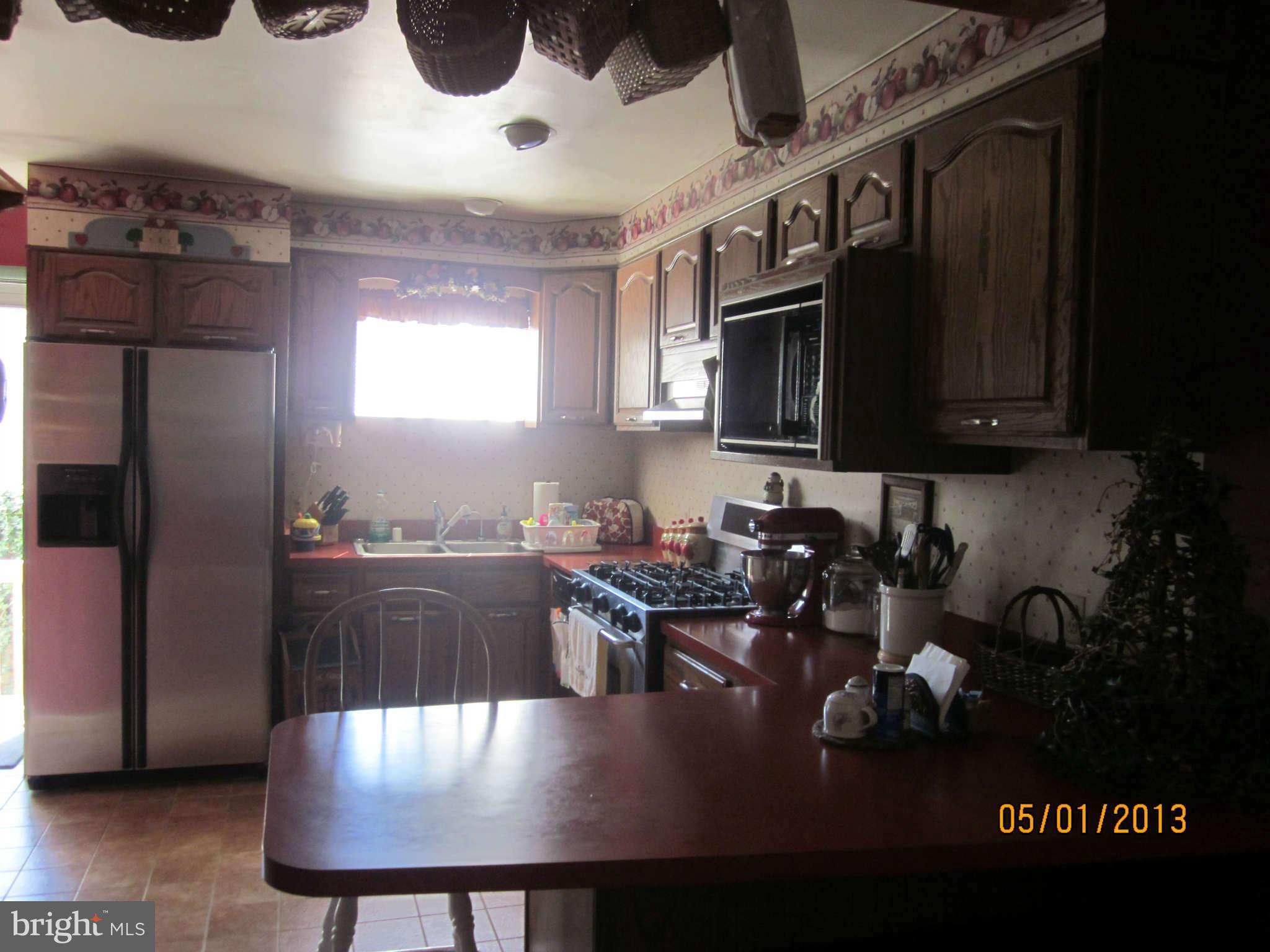 7617 Spruce Road Baltimore, MD 21222 - Photo 3 of 20 a kitchen with a table chairs stove and microwave