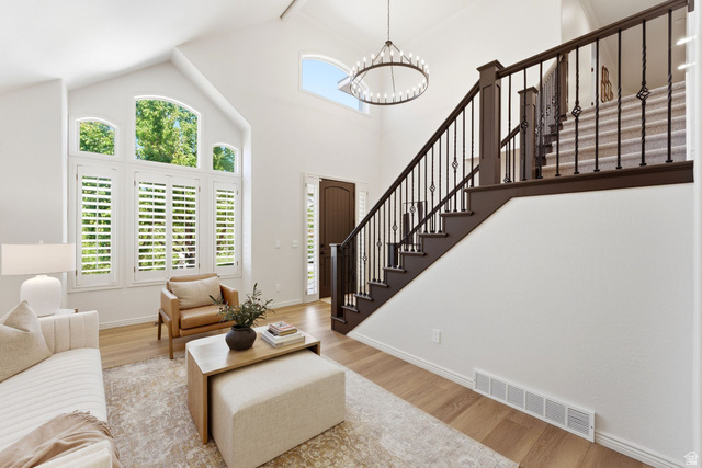 1712 Somerset Ridge Drive Draper, UT 84020 - Photo 12 of 76 Two-story foyer featuring a wood-finish flooring, a grand staircase with wrought iron balusters, a decorative chandelier, and a prominent arched window with plantation shutters