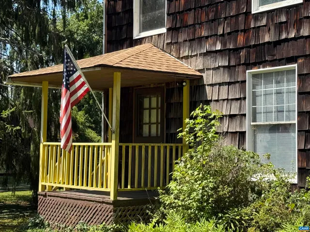 a view of a house with a small yard and wooden floor and fence