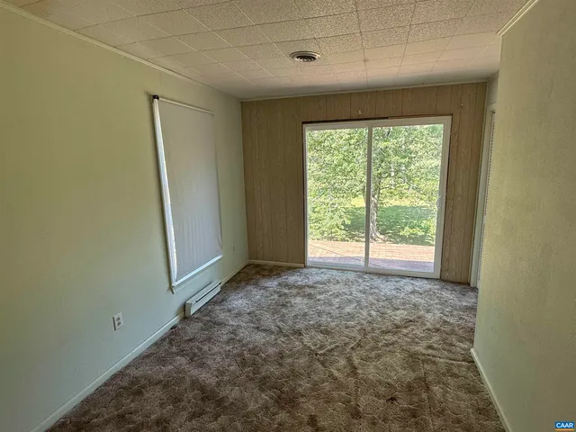 a view of a house with a small yard plants and large tree