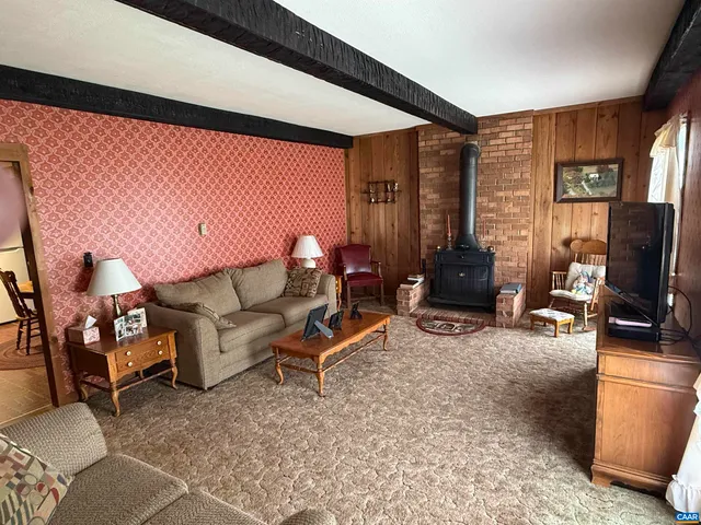 a living room with furniture a flat screen tv and a large window