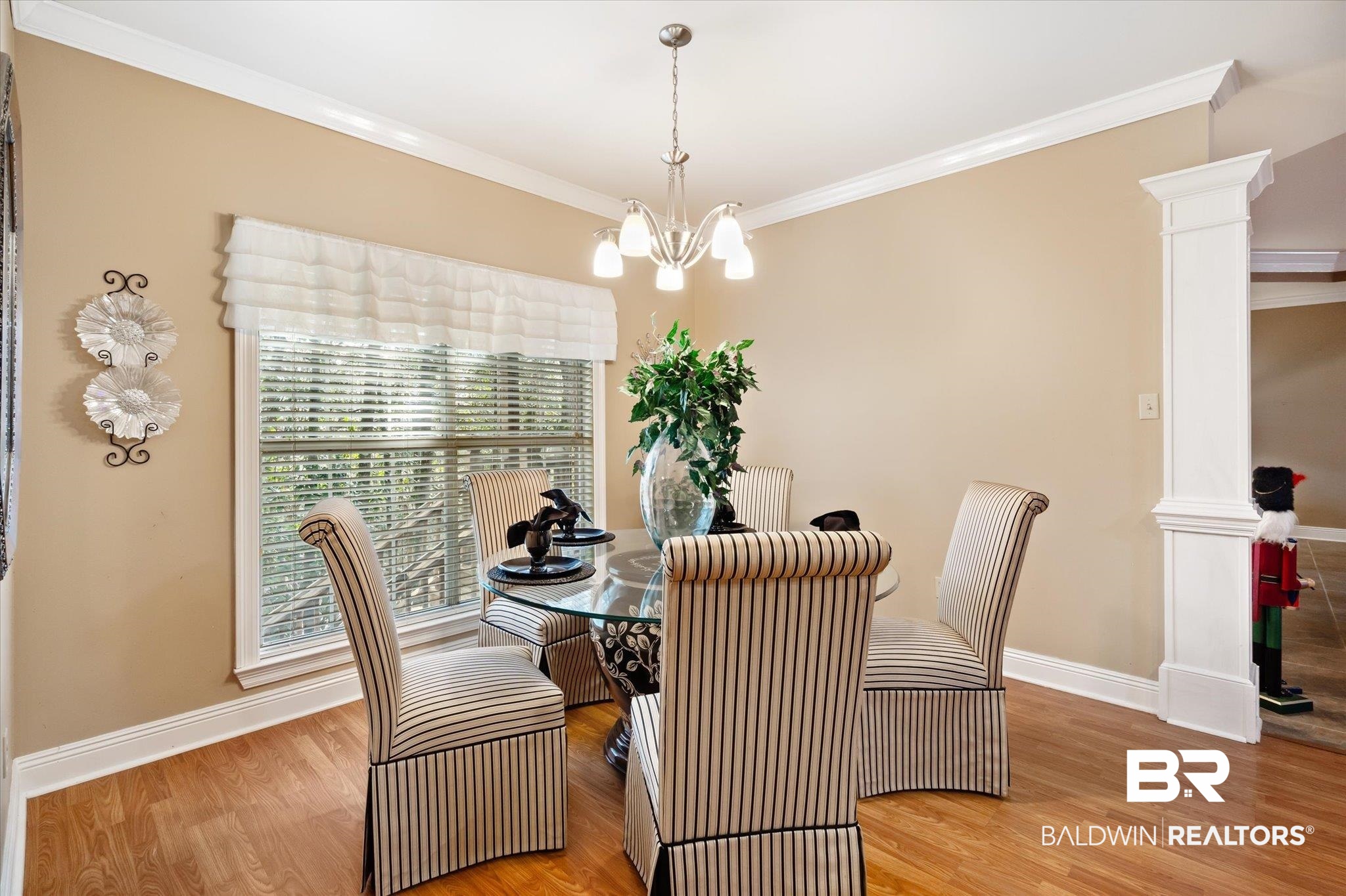 2400 Waterford Road Semmes, AL 36575 - Photo 12 of 30 Dining area featuring ornate columns, crown molding, wood finished floors, and a chandelier