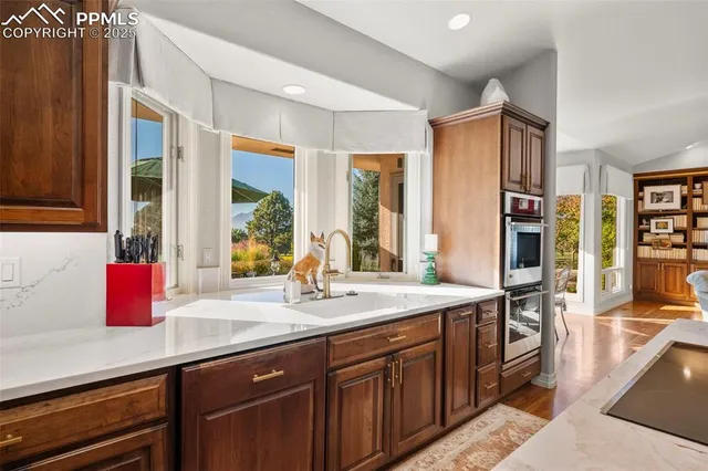 a kitchen with kitchen island granite countertop a sink and wooden cabinets