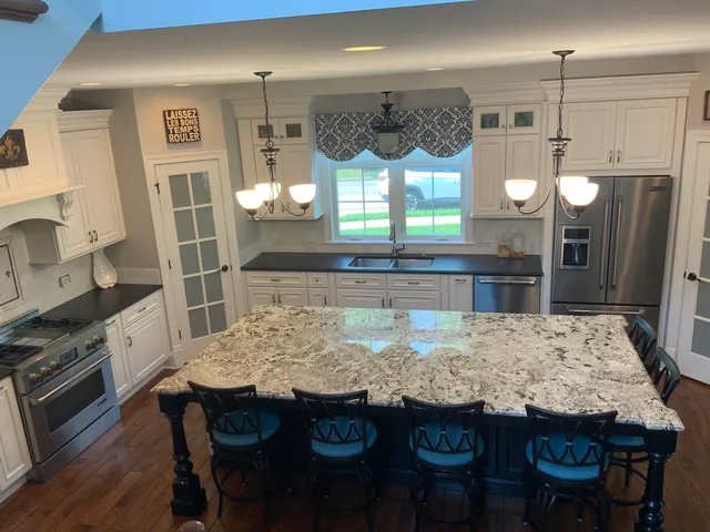 a kitchen with granite countertop a table and chairs in it