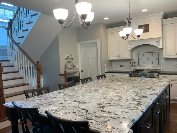 a kitchen with a table a chandelier and wooden floor