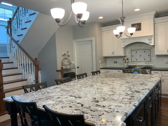 a kitchen with a table a chandelier and wooden floor