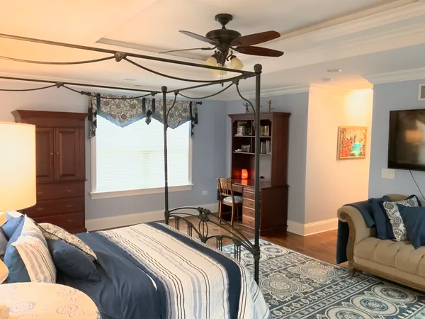 a bedroom with a bed a couch and flat screen tv