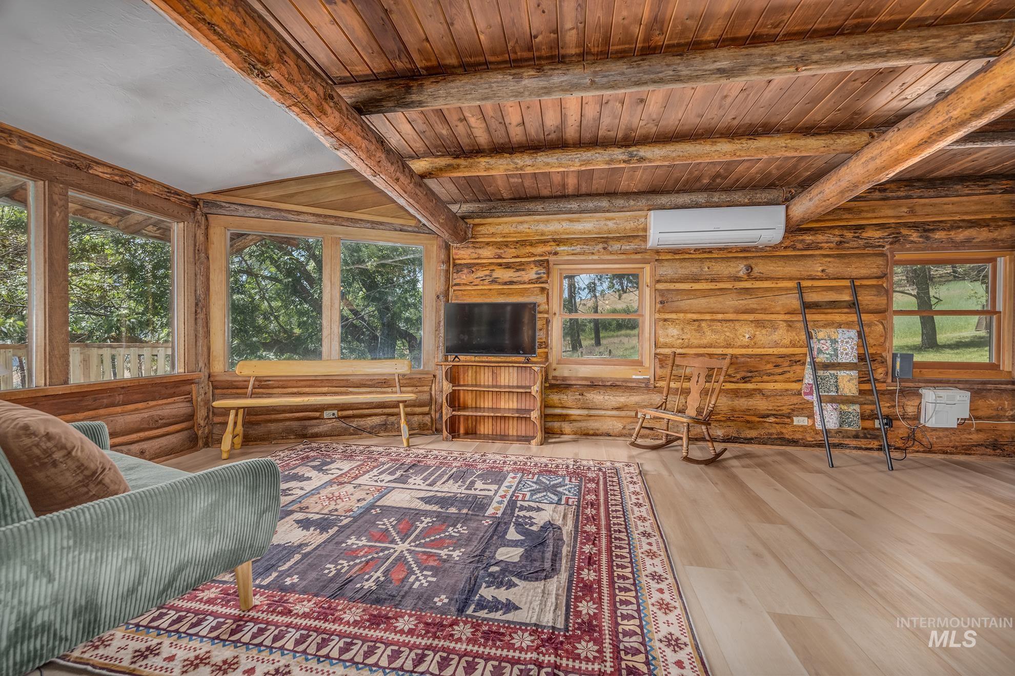 2150 Seid Creek Road Cambridge, ID 83610 - Photo 15 of 50 Room featuring log walls, wood-finish flooring, wood plank ceiling, and multiple windows