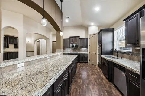 a kitchen with granite countertop stainless steel appliances and wooden cabinets