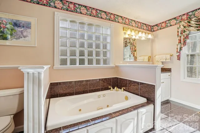 a bathroom with a tub a sink and a window