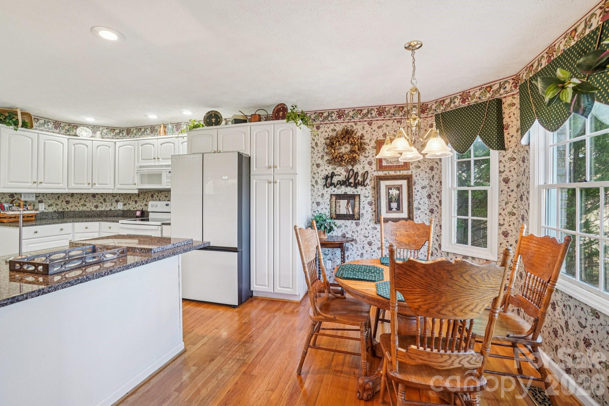4634 Harbor View Terrace Morganton, NC 28655 - Photo 22 of 39 a kitchen with stainless steel appliances granite countertop a refrigerator a stove and white cabinets with wooden floor