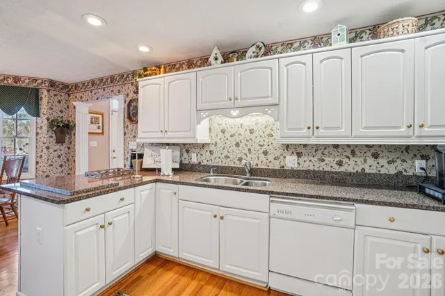 a kitchen with granite countertop white cabinets and white appliances
