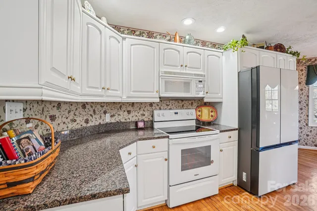 a kitchen with stainless steel appliances granite countertop a refrigerator sink and stove